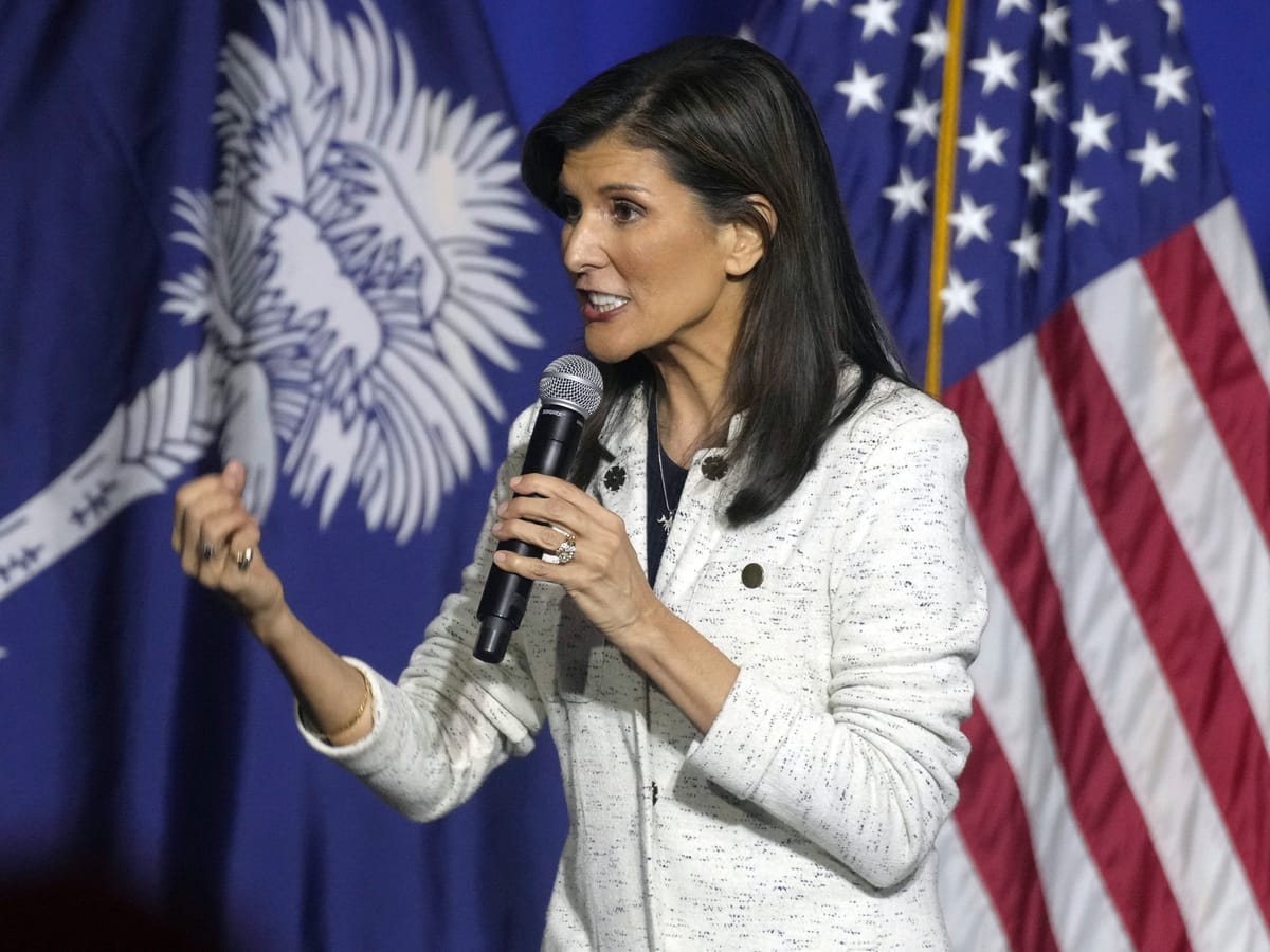 Former Gov. Nikki Haley speaking in front of flags